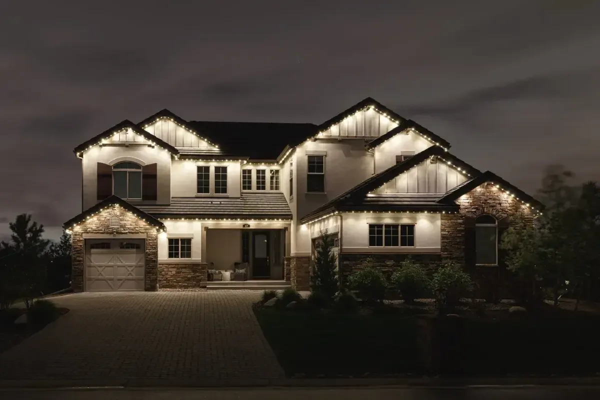 Warm white permanent exterior lighting on an Alpine Utah home roofline