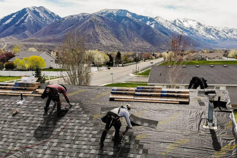 PowerHouse Roofing crew installing shingles on a Provo area roof with Wasatch Mountain views