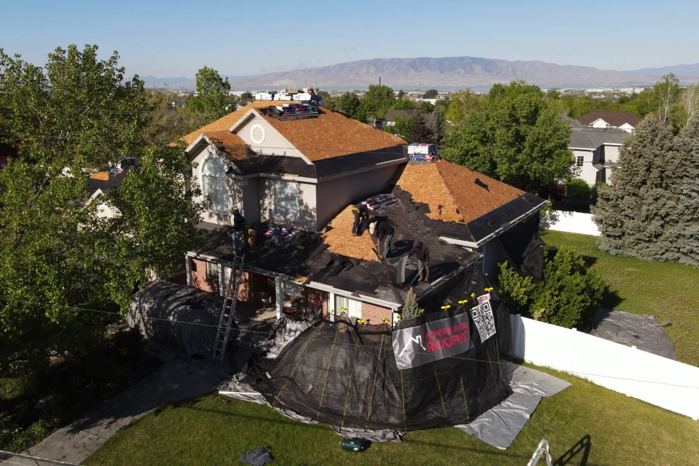 PowerHouse Roofing crew replacing a Utah County roof with site protection in place
