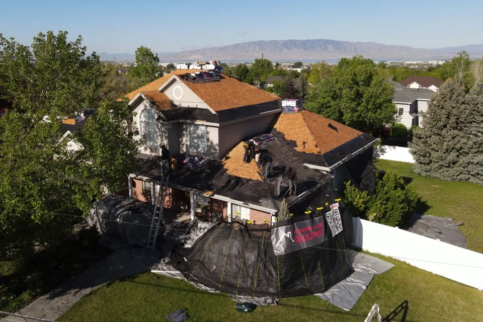 PowerHouse Roofing crew replacing a roof on a Utah County home with mountain views