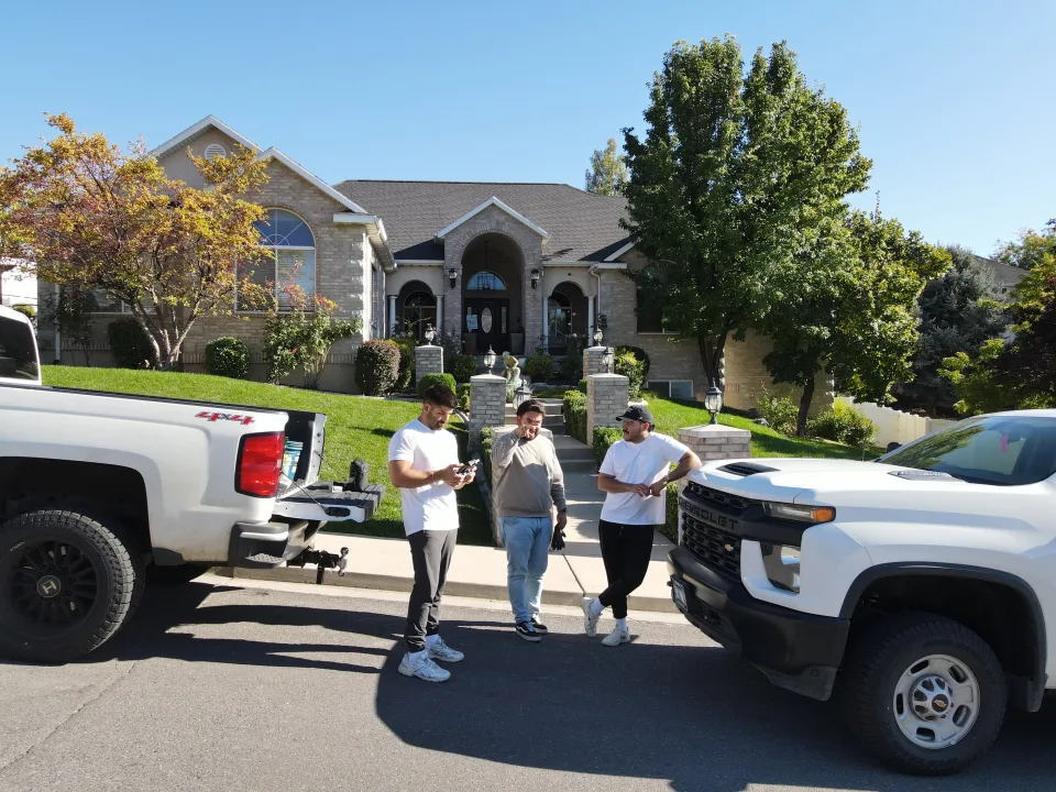PowerHouse Roofing team reviewing a Provo area home exterior before roof work